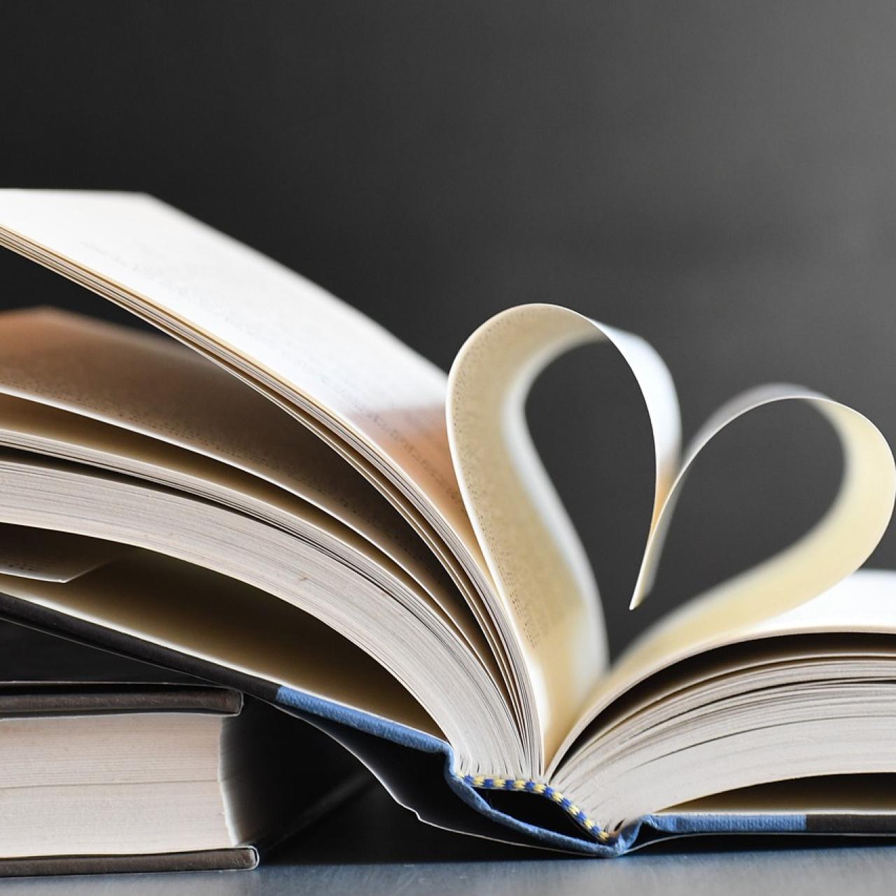 Aufgeklapptes Buch mit Seiten zu Herz gefaltet